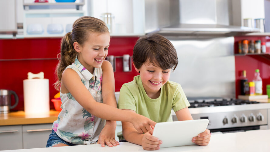 Happy siblings using table in the kitchen