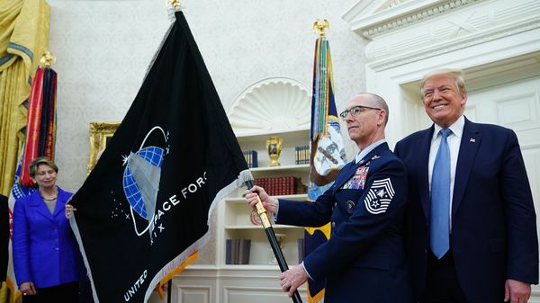 U.S. Space Force Senior Enlisted Advisor CMSgt Roger Towberman, standing with President Trump, presents the Space Force Flag in the Oval Office on March 15.
