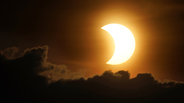 The sun is partially eclipsed as it rises over lower Manhattan in New York on Thursday.