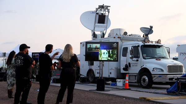 People watch on a television screen as the New Shepard Blue Origin rocket sits on the launch pad before Jeff Bezos along with his brother Mark Bezos, 18-year-old Oliver Daemen, and 82-year-old Wally Funk prepare to launch on Tuesday in Van Horn, Texas. Mr. Bezos and the crew are riding in the first human spaceflight for the company.