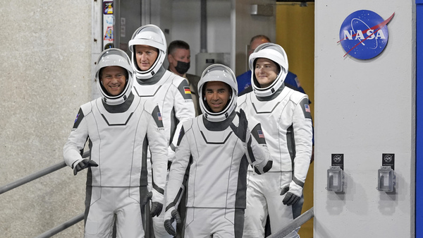 Astronauts, from left, Tom Marshburn, Matthias Maurer, of Germany, Raja Chari and Kayla Barron wave as they leave the Operations and Checkout building for a trip to Launch Pad 39-A on Wednesday at the Kennedy Space Center.