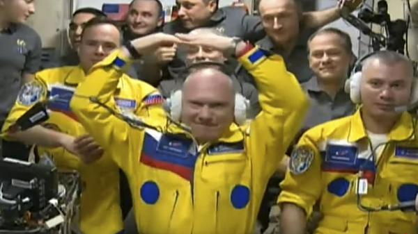 In this photo taken from video footage released by the Roscosmos Space Agency, three Russian cosmonauts sport yellow spacesuits upon arriving on the International Space Station. A NASA astronaut now says it was not in support for Ukraine, but for the Russians