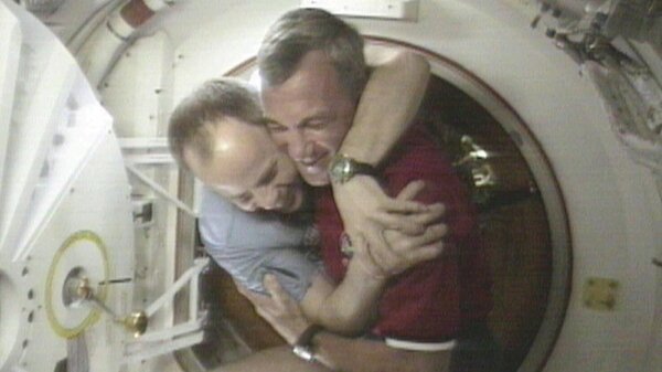 U.S. Space Shuttle Commander Terrence Wilcutt (right) and Mir Commander Anatoly Solovyev hug after opening the hatches between the space shuttle Endeavour and the Russian Space station Mir Saturday, Jan. 24, 1998, in this image from television