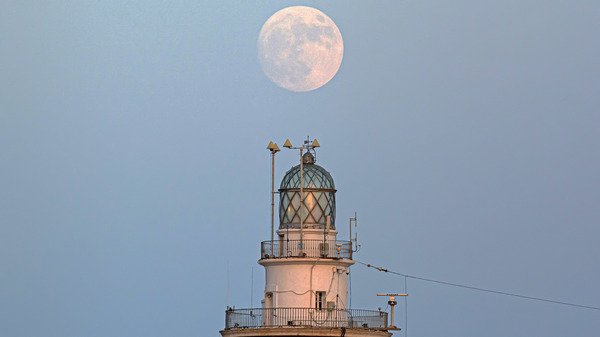 Malaga, Spain: The full moon is rising over the Malaga lighthouse. The supermoon, also known as the buck moon, will be visible through Friday morning.