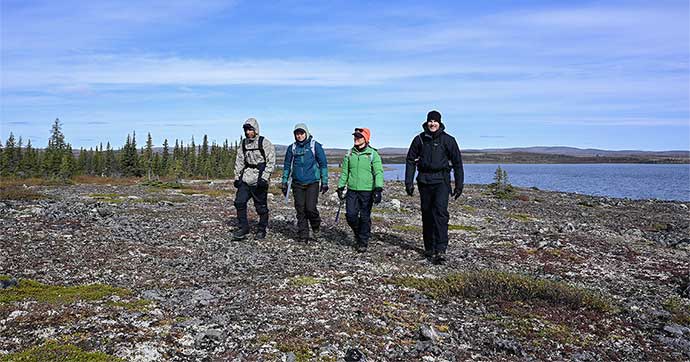 Four astronauts walking on a mountain during a geology training