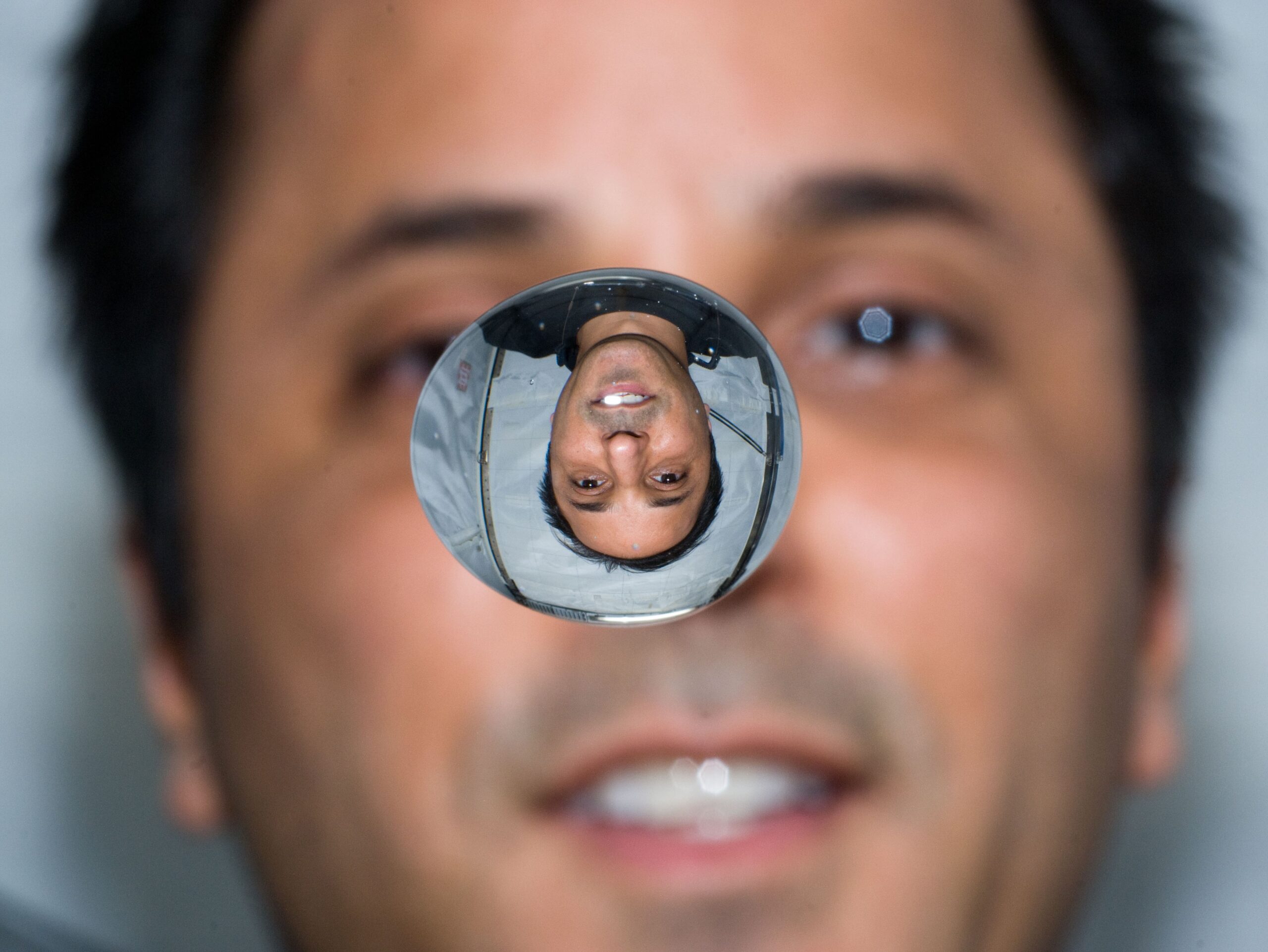 NASA astronaut Joseph M. Acaba refracted in a globule of water.