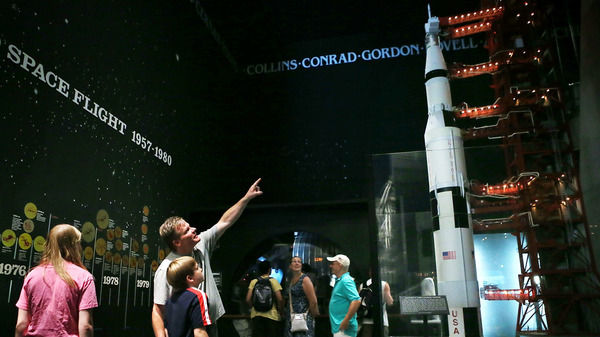 Visitors look at a model of a Saturn V rocket and its launch umbilical tower, which were used during the Apollo moon-landing program, at the Smithsonian National Air and Space Museum in Washington, D.C. Fifty years ago this July 20, Neil Armstrong and Buzz Aldrin became the first humans to walk on the moon.