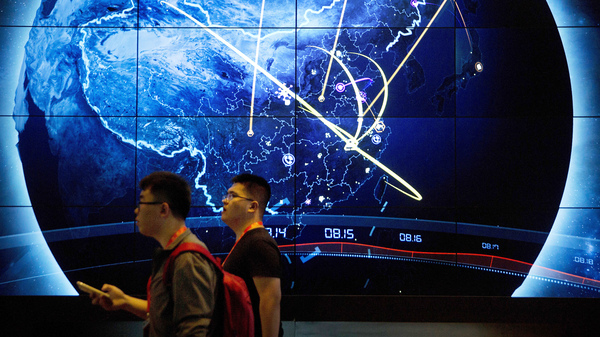 Attendees walk past an electronic display showing cyberattacks in China at the 2017 China Internet Security Conference in Beijing.