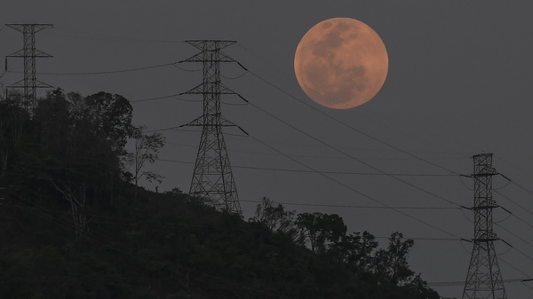 A full moon rises behind the high voltage towers of the El Avila in Caracas, Venezuela, Sunday, May 15. People in the Americas, Europe and Africa will see the total lunar eclipse during the night of May 15-16.