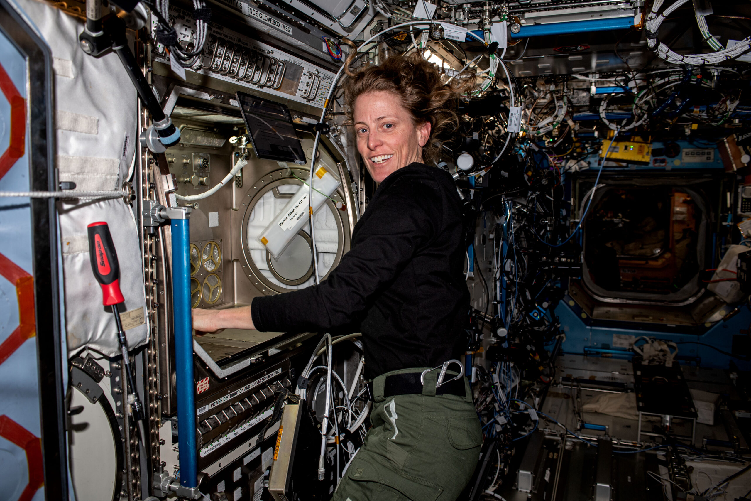 NASA astronaut and Expedition 70 Flight Engineer Loral O'Hara is pictured working with the Microgravity Science Glovebox, a contained environment crew members use to handle hazardous materials for various research investigations in space.