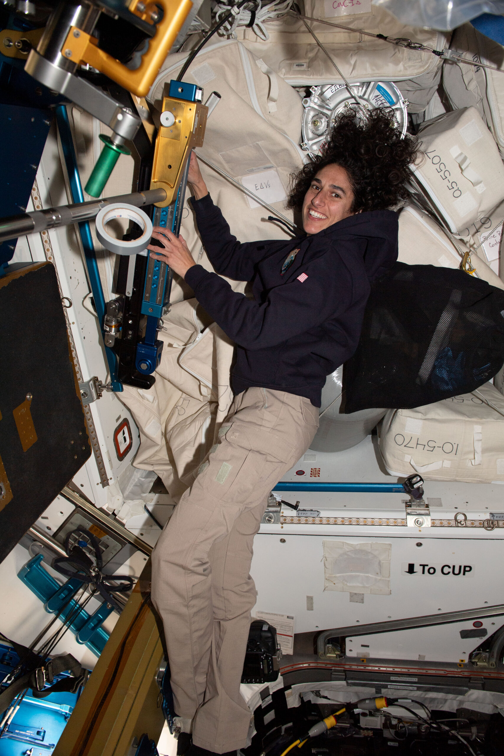 NASA astronaut and Expedition 70 Flight Engineer Jasmin Moghbeli replaces cables on the advanced resistive exercise device inside the International Space Station's Tranquility module.