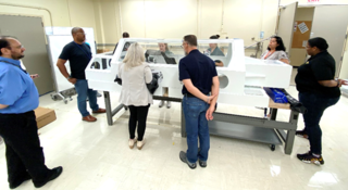 NASAs OSIRIS-REx curation team from Johnsons ARES division and visiting mission team members practice the sample pour in a mock-up glovebox in Building 36 at Johnson in May 2023.